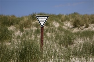 Dune landscape with sign for dune protection and the request not to enter