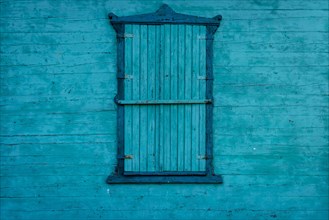 Blue shutters. Wooden wall painted with blue paint. Poland