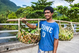 Local farmer bringing his goods in palm baskets back home