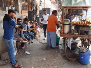 People eating a meal at a street food stall