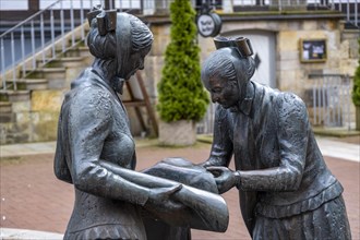 Sculpture of two linen weavers at the fountain in front of the town hall in Luechow