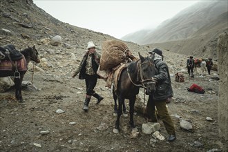 Two men loading a packhorse