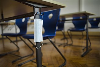 Mouth mask hangs on student's desk