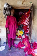 Shopkeeper before his shop full of colourful leather