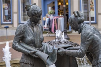 Sculpture of two linen weavers at the fountain in front of the town hall in Luechow