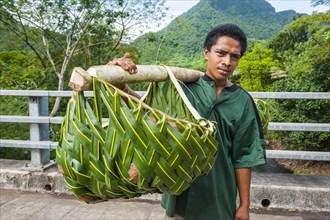 Local farmer bringing his goods in palm baskets back home
