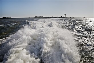 The passenger ship Adler Express moves away at high speed from Hallig Hooge