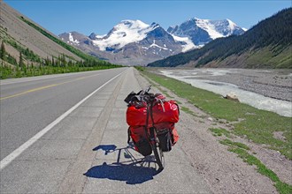 Loaded red touring bike on straight road