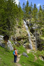 Hiker in front of the Arzmoos waterfall
