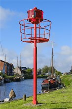 Mast with red position lamp in harbour