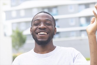 Young black man laughing outside in the summer of the city