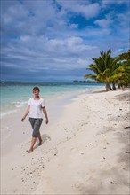 Woman walking along Lano beach in SavaiÂ´i