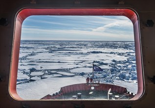 Look through a window of an icebreaker breaking the ice on its way up to the North Pole