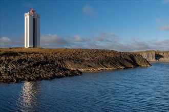 Lighthouse and coastal landscape with basalt formations and basalt cliff