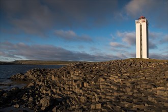 Lighthouse and coastal landscape with basalt formations