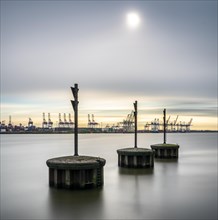 Long exposure of concrete bollards in the river Elbe at the port of Hamburg
