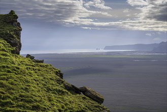 View from Hjoerleifshoefdi (Viking grave) across wide expanse of lava sand to Reynisdrangar