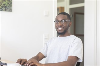 Young black man working at desk in office