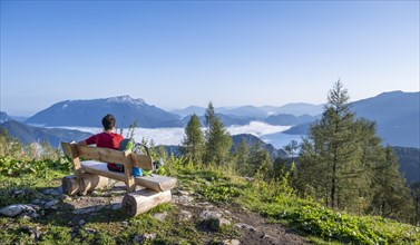 Hiker sits on a bench and looks over the landscape