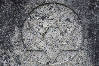 Weathered Star of David on a gravestone