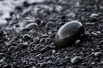 Wet black pebbles on the beach