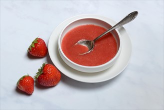 Strawberry sauce in bowl and strawberries