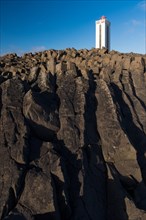 Lighthouse and coastal landscape with basalt formations