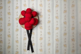Original Black Forest Bollen hat in front of old-fashioned wallpaper wall
