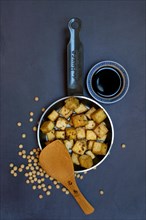 Fried tofu cubes in pan and soy sauce