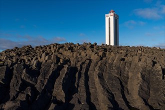 Lighthouse and coastal landscape with basalt formations