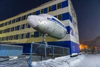 Airplane sticking out of a building