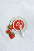 Strawberry sauce in bowl and strawberries