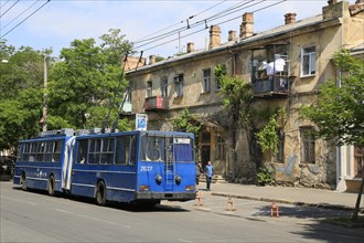 Trolleybus and house facade in need of renovation in Primorski district