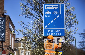 Construction worker cleaning traffic sign