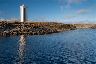 Lighthouse and coastal landscape with basalt formations and basalt cliff