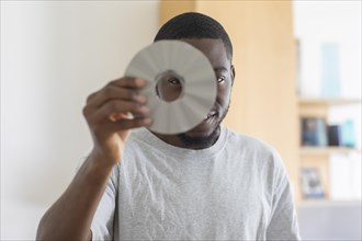 Young black man holding a disc as an idea