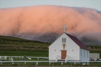 Church in front of cloud in evening light