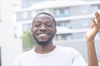 Young black man laughing outside in the summer of the city