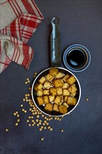 Fried tofu cubes in pan and soy sauce