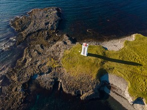 Lighthouse and coastal landscape with basalt formations