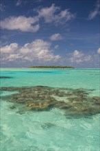 Little island in the turquoise waters in the Aitutaki lagoon