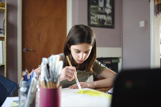 Young teenage girl painting