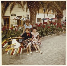 Three young German holidaymakers sitting on the beach promenade of Finale Ligure