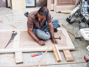 Craftsman shaping a wooden door