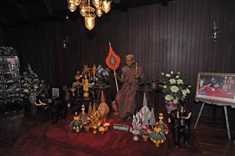 Darkened worship room with monk statue in Buddhist monastery Wat Chalong