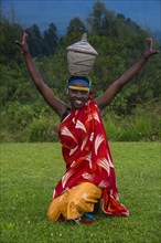 Woman carrying a basket on her hat at a ceremony of former poachers
