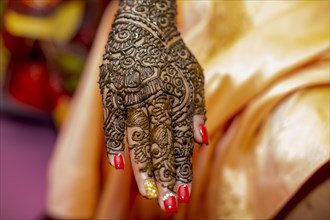 Hand of a Hindu bride painted with henna on the eve of her wedding in Beau-Bassin