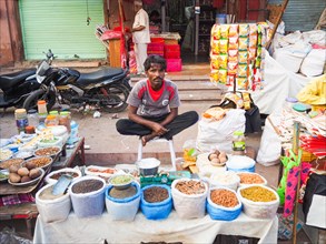 Vendor offering pulses at market stall