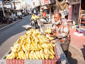 Vendor offering bananas at market stall
