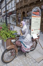 Witch figure on an old moped as an advertising medium for the castle railway